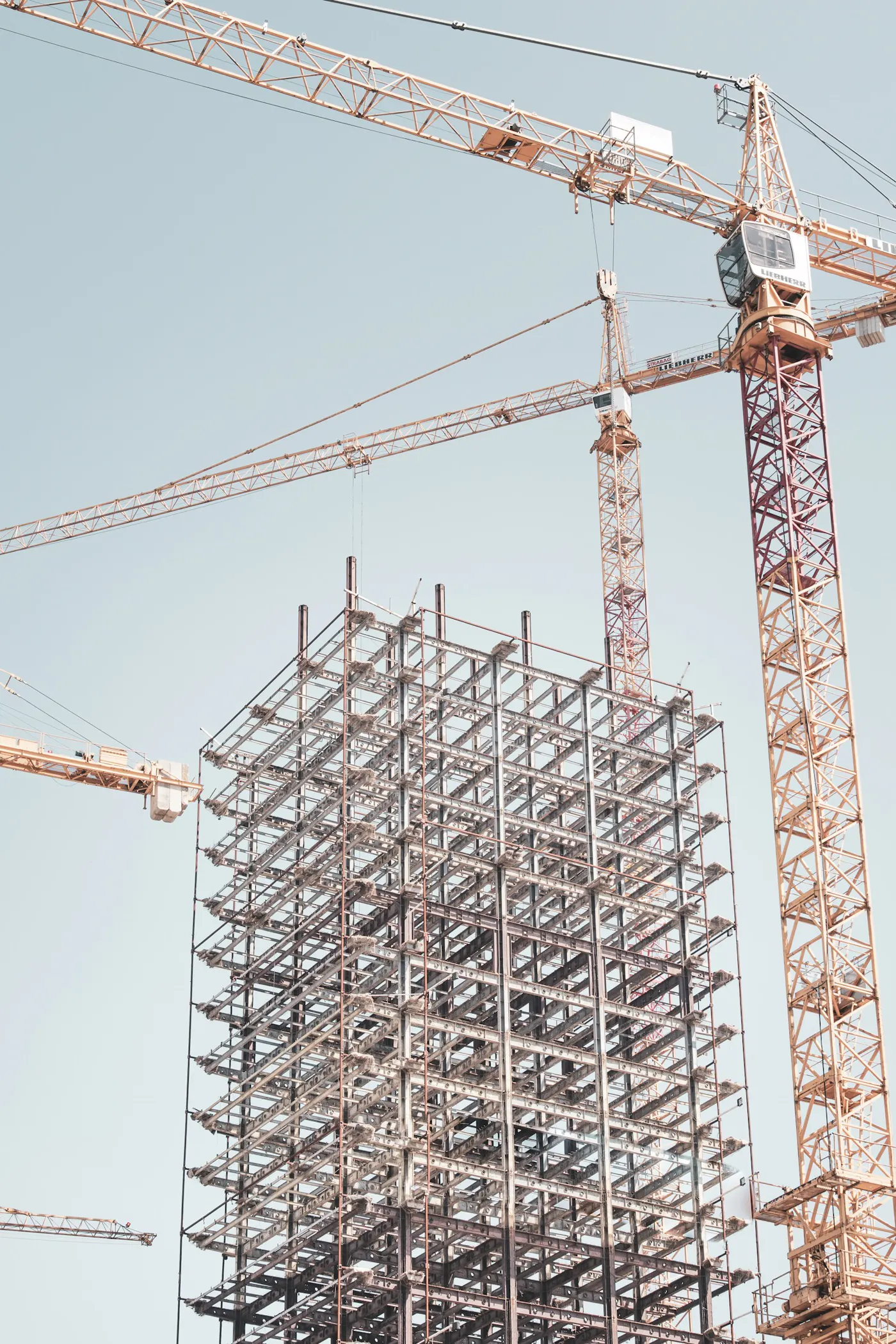 Una estructura de acero en construcción junto a una grúa torre